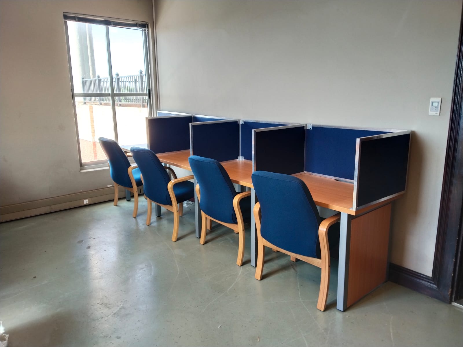 Row of navy privacy carrels with timber chairs
